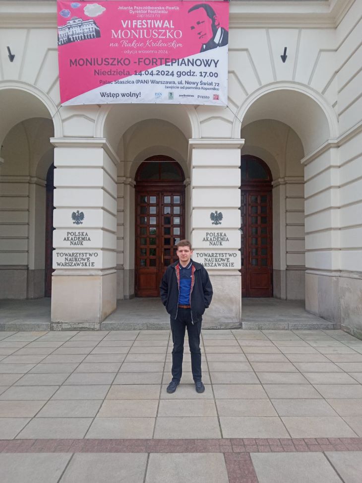 młody mężczyzna na tle Pałacu Staszica w Warszawie